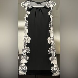 Sleeveless black midi dress with gray/white flowers on sides. Stretchy fabric